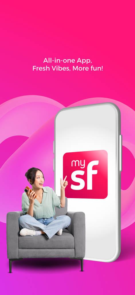 A woman sitting in a chair and pointing at the MySmartfren app logo on a large smartphone screen
