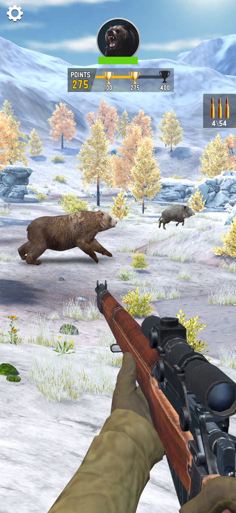 Sniper Shooter Wild - Eine Ego-Perspektive, bei der ein Spieler mit einem Scharfschützengewehr auf einen Grizzlybären und ein Wildschwein in einer verschneiten Bergumgebung zielt.