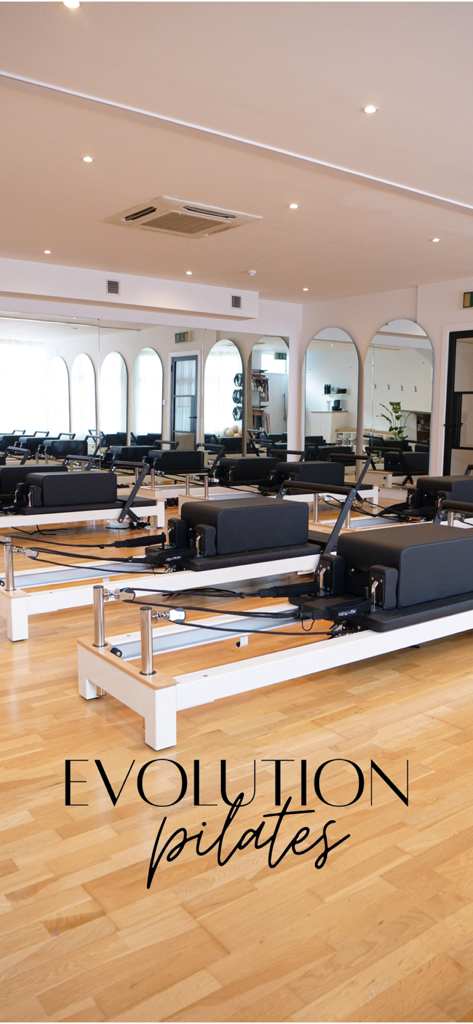 Evolution Pilates - Modern Evolution Pilates studio interior with professional reformer machines and large arched mirrors