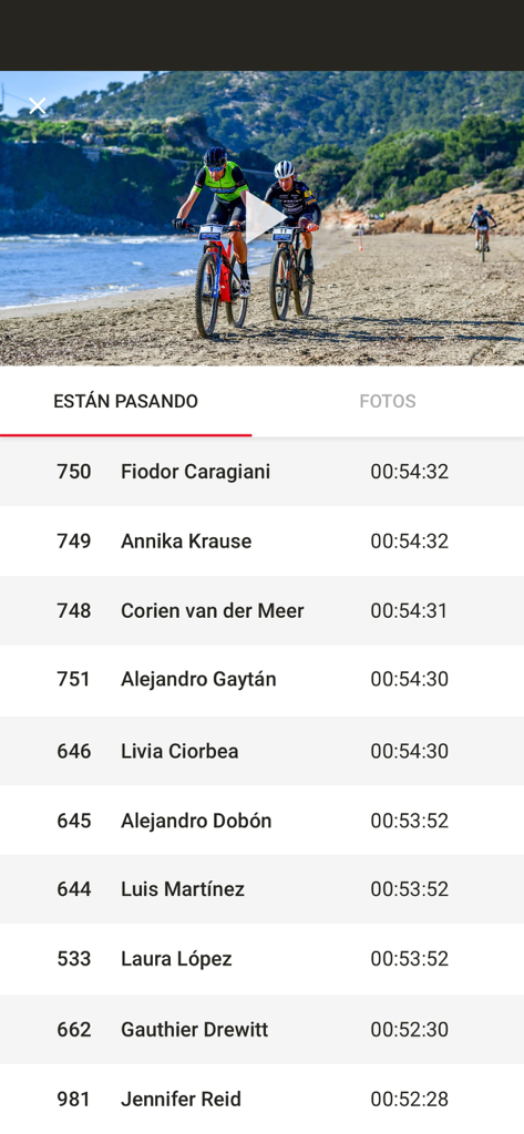 Tela do aplicativo Publicom Live exibindo um vídeo de corrida de mountain bike e uma lista em tempo real dos tempos de chegada dos atletas