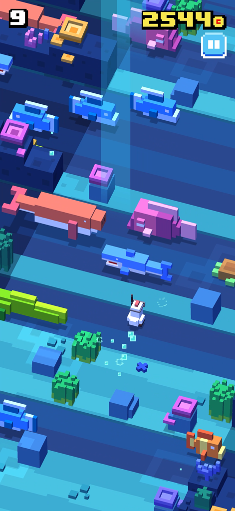 Un personaje de vóxel nada a través de un nivel submarino lleno de tiburones y delfines en Crossy Road