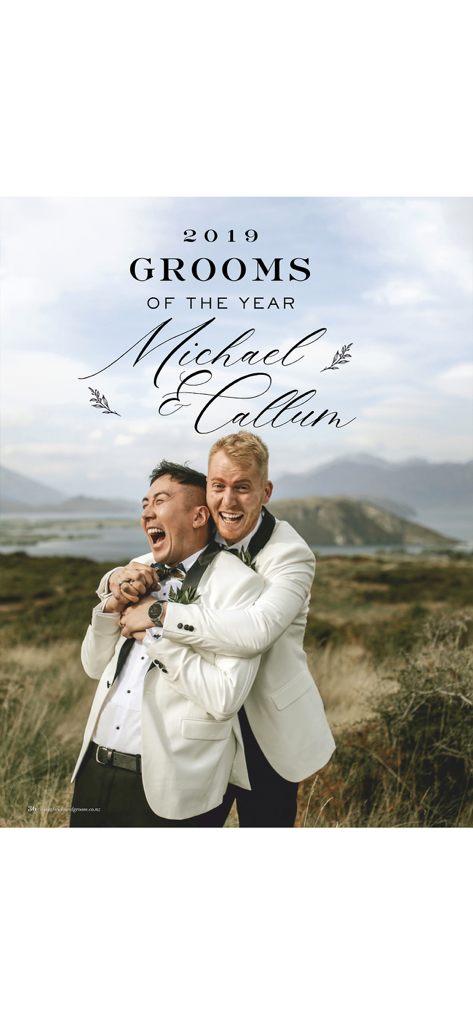Two grooms in white tuxedo jackets laughing and hugging in a scenic outdoor wedding photoshoot