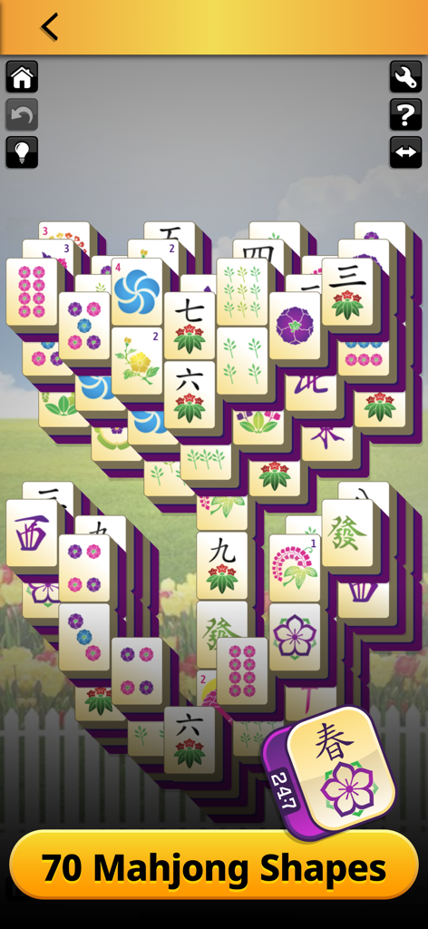 247 Games - Mahjong solitaire gameplay in the 247 Games app featuring a flower-shaped tile layout and a spring garden theme background.