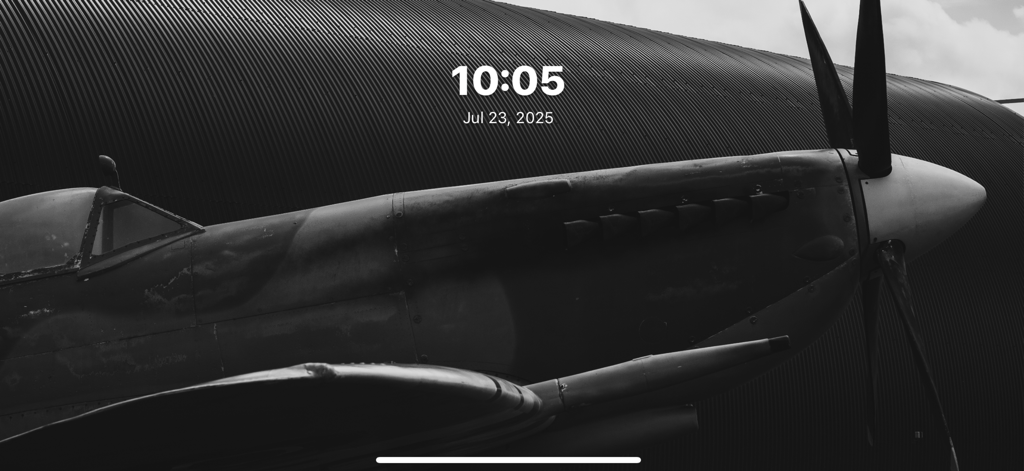 FotoSlide app displaying a black and white vintage airplane photo with a minimalist digital clock and date overlay