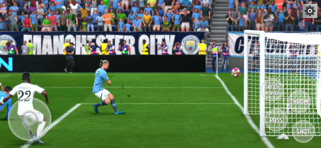 Play Football Games 2025 Goals - Un jugador de fútbol con uniforme azul patea el balón hacia la portería en un estadio abarrotado durante el juego