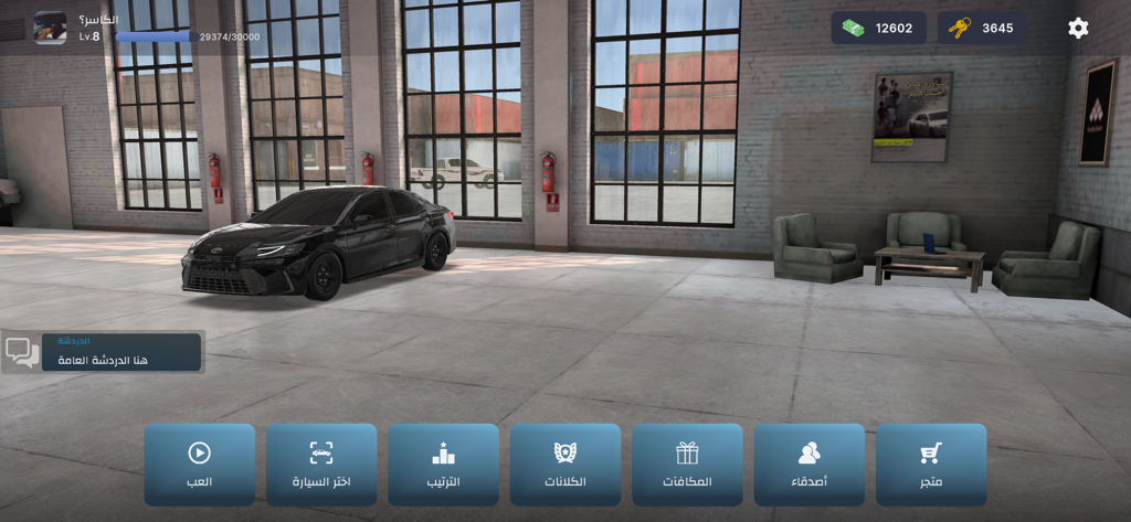 هجولة الطارة - Un coche negro dentro de un garaje en el lobby del juego de drift Hajwala Al Tarah con iconos de menú árabes