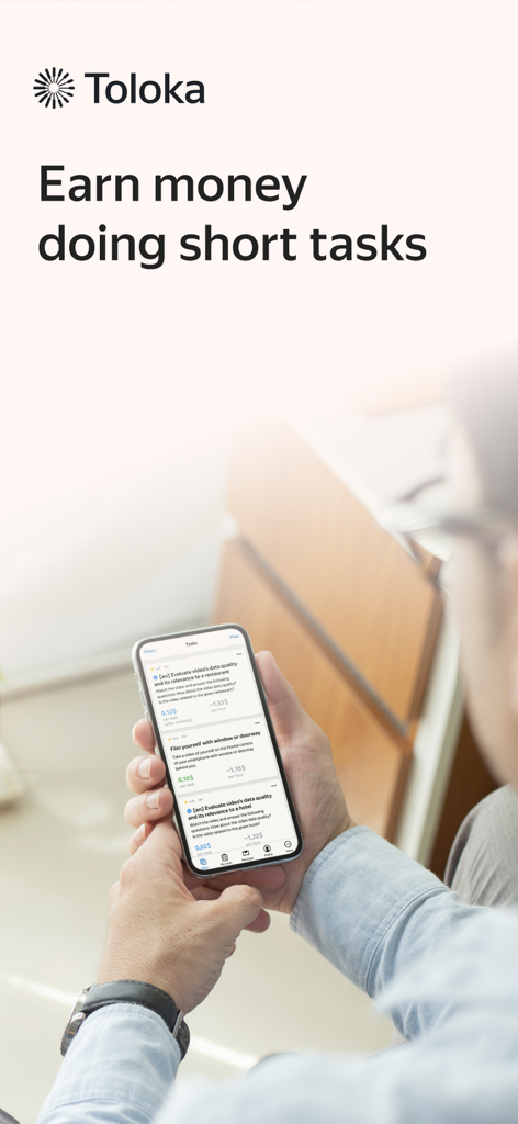 Toloka: Earn online - A person using the Toloka app on a smartphone to earn money by completing short micro-tasks.