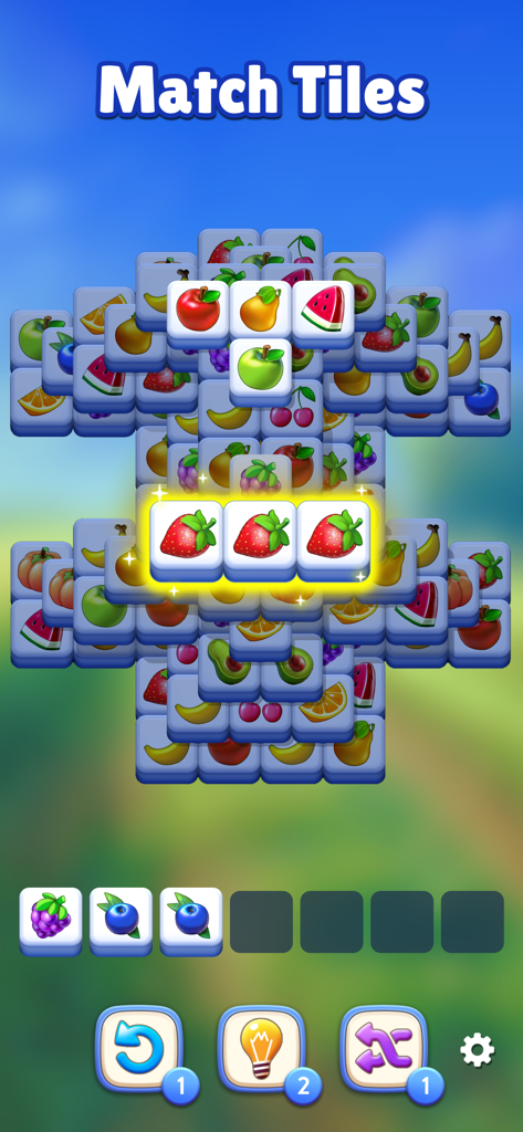 Gameplay screenshot of Fruit Match showing a stack of 3D fruit tiles with three strawberries matched