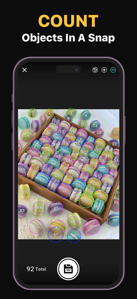 Count Things Ai Object Counter - Una pantalla de teléfono inteligente que muestra la aplicación Count Things Ai contando y numerando automáticamente 92 macarons coloridos en una bandeja de madera.