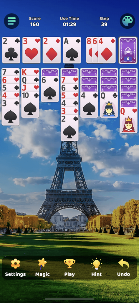 Classic Klondike Solitaire game being played with a scenic Eiffel Tower background