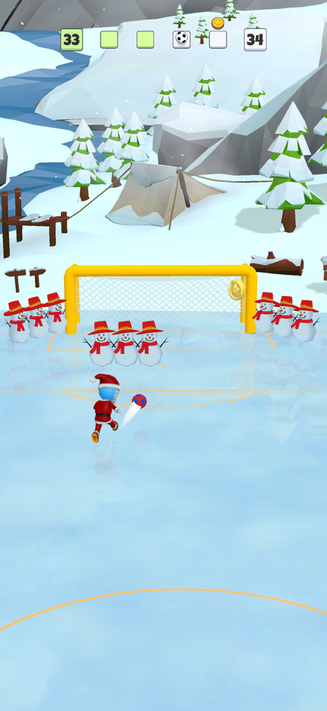 A character in a Santa suit kicks a soccer ball towards a goal guarded by snowmen in a winter themed level.