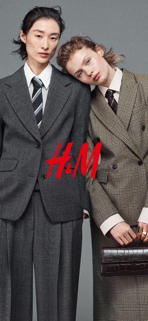 Two models wearing tailored H&M suits and ties with the red H&M logo