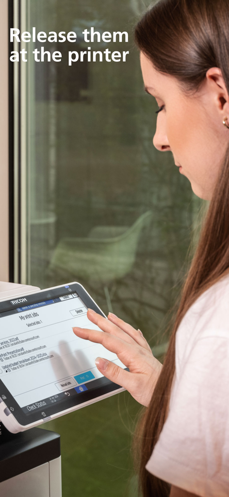 RICOH CloudStream - A professional woman releasing print jobs at a RICOH printer touchscreen