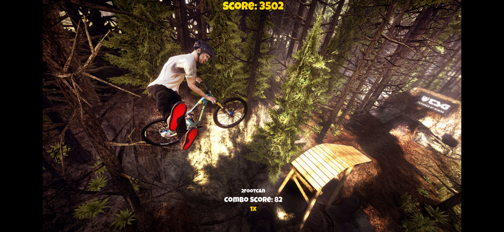 Shred! 2 - ft Sam Pilgrim 2023 - Un mountain biker esegue un trick in un ambiente forestale nel gioco mobile Shred! 2.