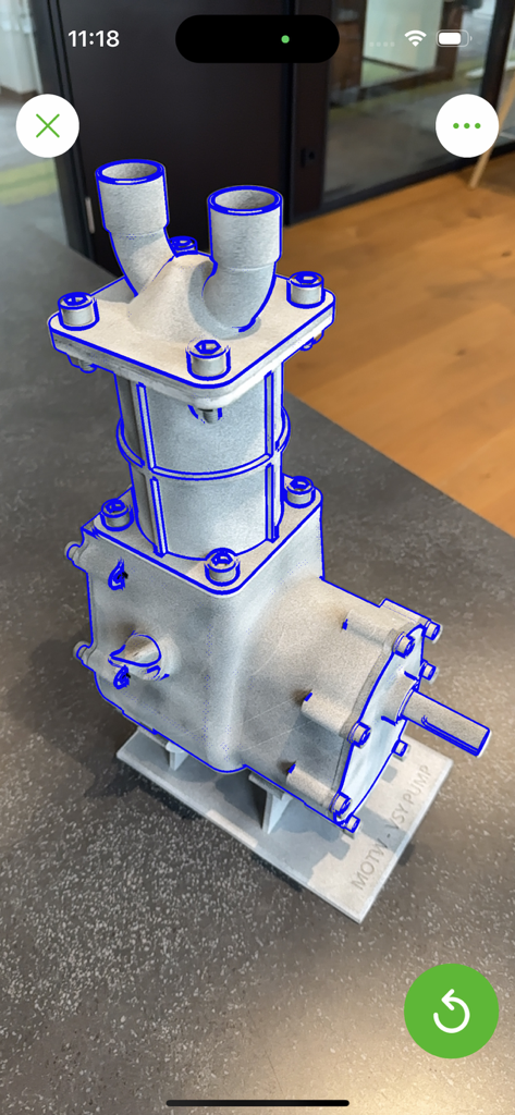 Una bomba industrial rastreada en realidad aumentada con contornos azules en la aplicación Vuforia Creator