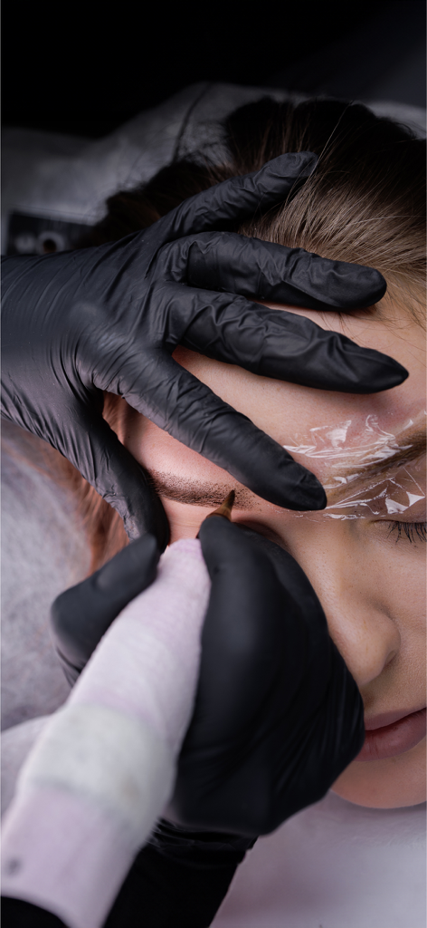 Tattoomorrow - Close up of a professional permanent makeup artist tattooing a clients eyebrows