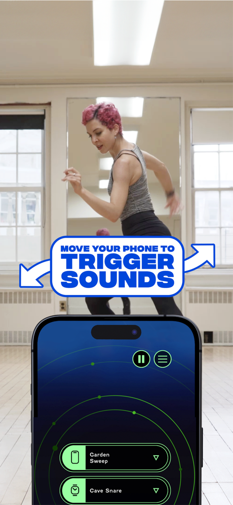 WORM.dance - A woman dancing in a studio with a phone displaying the WORM.dance app interface for movement triggered sounds