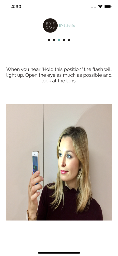 EyeCos EYE Selfie - Una mujer sosteniendo su iPhone para capturar una selfie ocular de alta resolución usando las instrucciones de la aplicación EyeCos