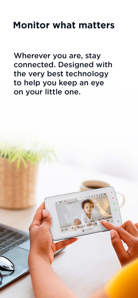 Handheld Motorola monitor displaying a live video feed of a baby