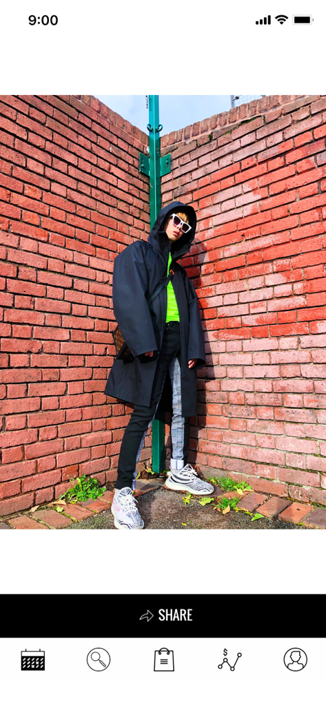 KicksOnFire: Release Dates - Una persona joven con ropa urbana y zapatillas posando contra una pared de ladrillos rojos dentro de la interfaz de la aplicación KicksOnFire