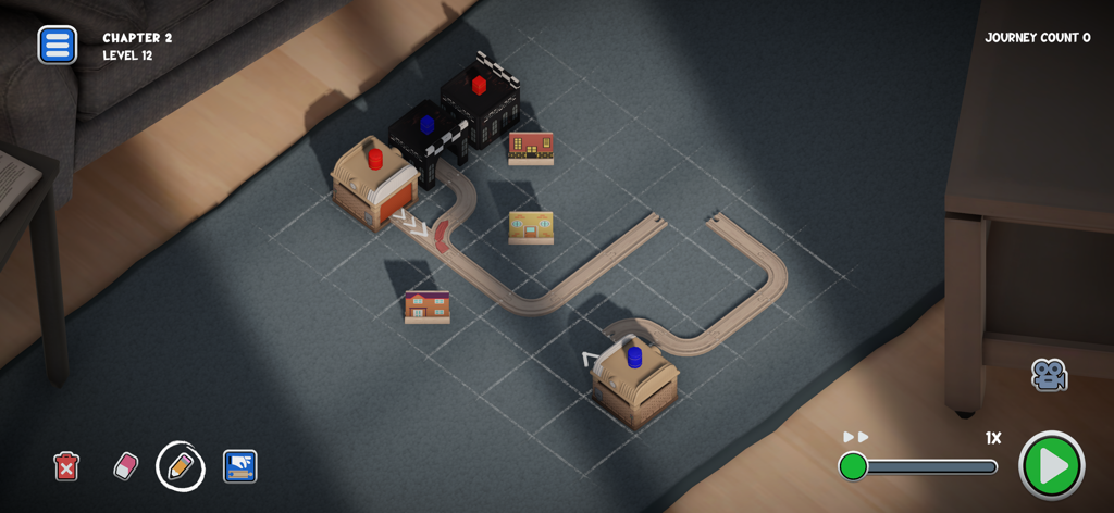 Teeny Tiny Trains - Una vista dall'alto di un livello di gioco rompicapo per treni in legno con binari e piccoli edifici su un pavimento coperto di moquette