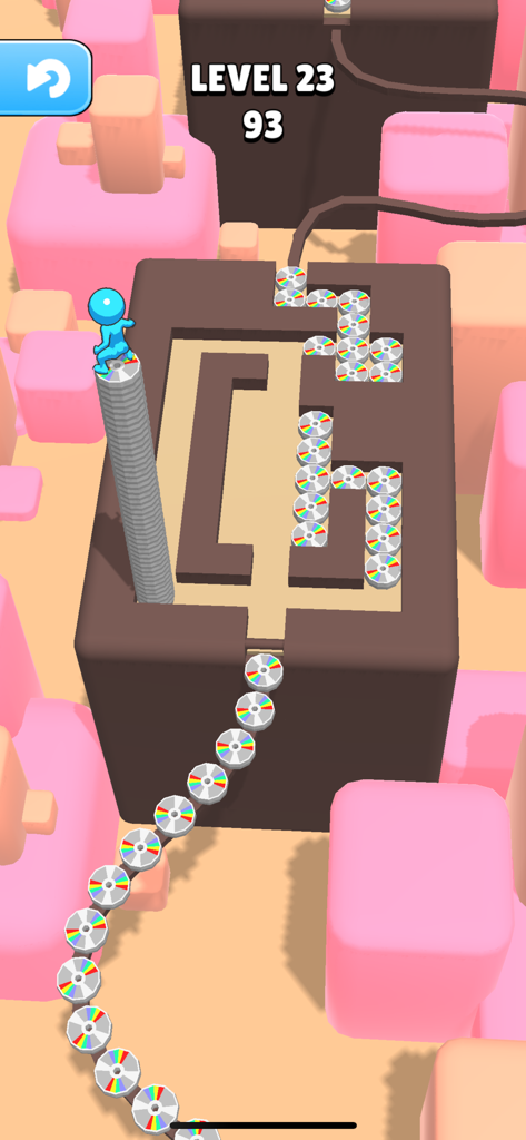 Blue character standing on a tall stack of rainbow tiles in a maze level