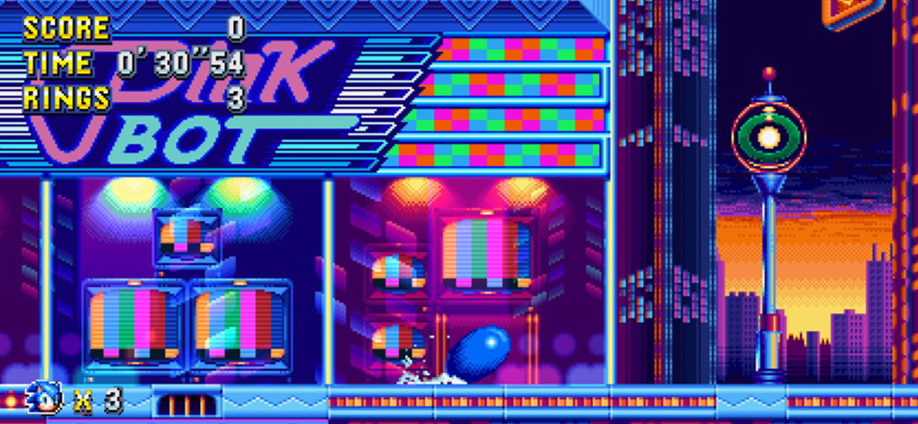 Sonic Mania Plus - NETFLIX - Uno screenshot di gioco di Sonic Mania Plus che mostra un vibrante livello urbano al neon a 16 bit con monitor televisivi retrò.