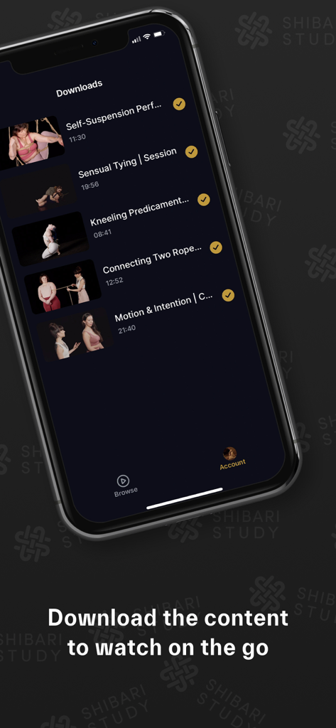 Um smartphone exibindo a seção de downloads do aplicativo Shibari Study com uma lista de vídeos educacionais de arte com corda prontos para visualização offline.