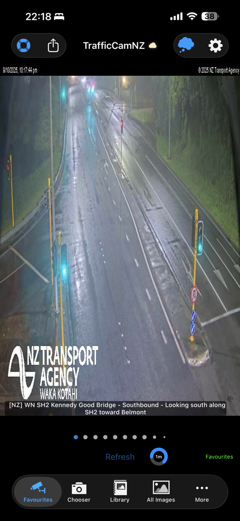 TrafficCamNZ app showing a live nighttime traffic camera feed of a wet highway from the NZ Transport Agency