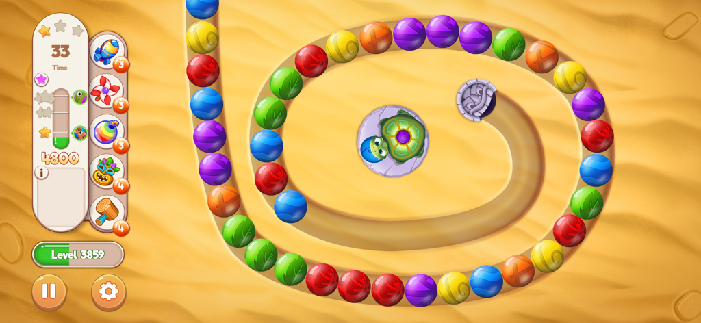 모래 위 나선형 경로에 놓인 다채로운 마블과 거북이 캐릭터가 등장하는 마블 슈팅 게임 플레이