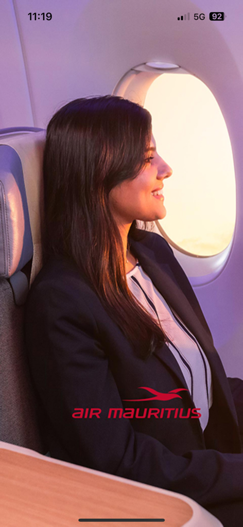A woman smiling while looking out of the window on an Air Mauritius flight