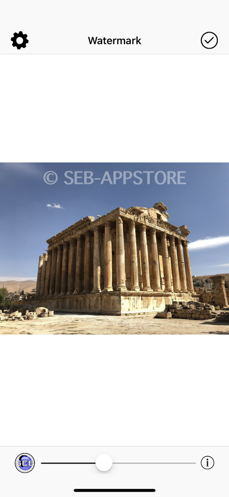 Oberfläche der WaterMark App, die einen Textwasserzeichen-Overlay auf einem Foto eines antiken Tempels mit einem Deckkraftschieberegler zeigt