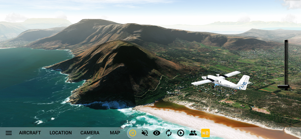 A white plane flying over a mountainous coast and ocean in GeoFS