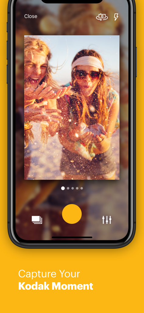KODAK SMILE - Smartphone screen showing the KODAK SMILE app camera interface capturing two young women blowing glitter.