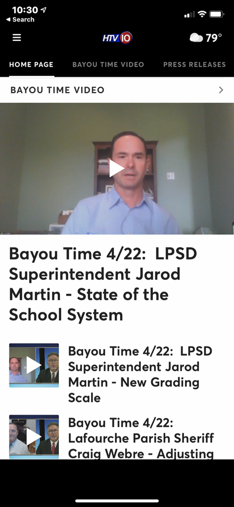Tela do aplicativo móvel HTV10 mostrando o noticiário local Bayou Time em vídeo sobre o sistema escolar