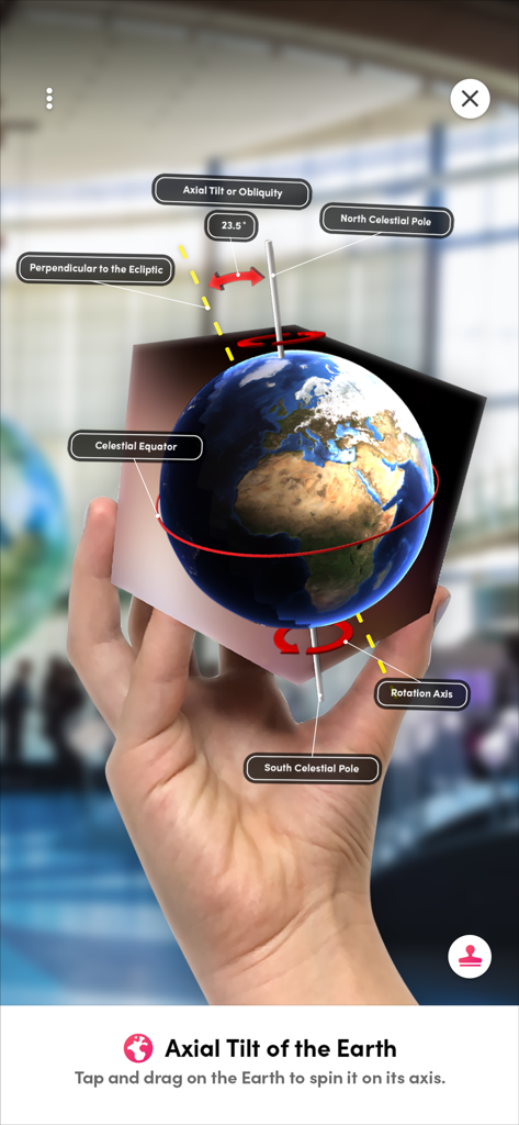 Merge Explorer - A hand holding a Merge Cube displaying an augmented reality model of Earth showing its axial tilt and rotation axis.