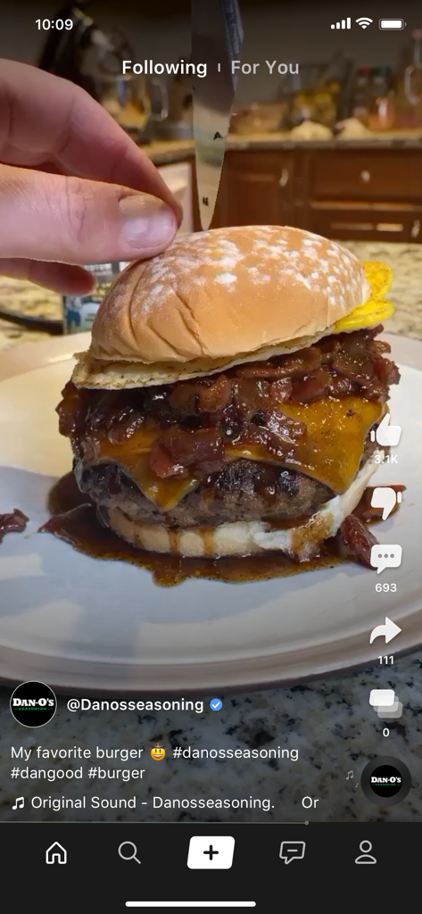 Screenshot of the Clapper mobile app interface showing a close-up short video of a gourmet burger with melted cheese and seasonings.