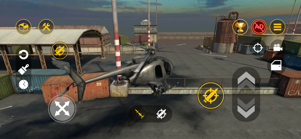 A military helicopter flying in a sandbox environment with shipping containers and industrial buildings in BloodBox Sandbox