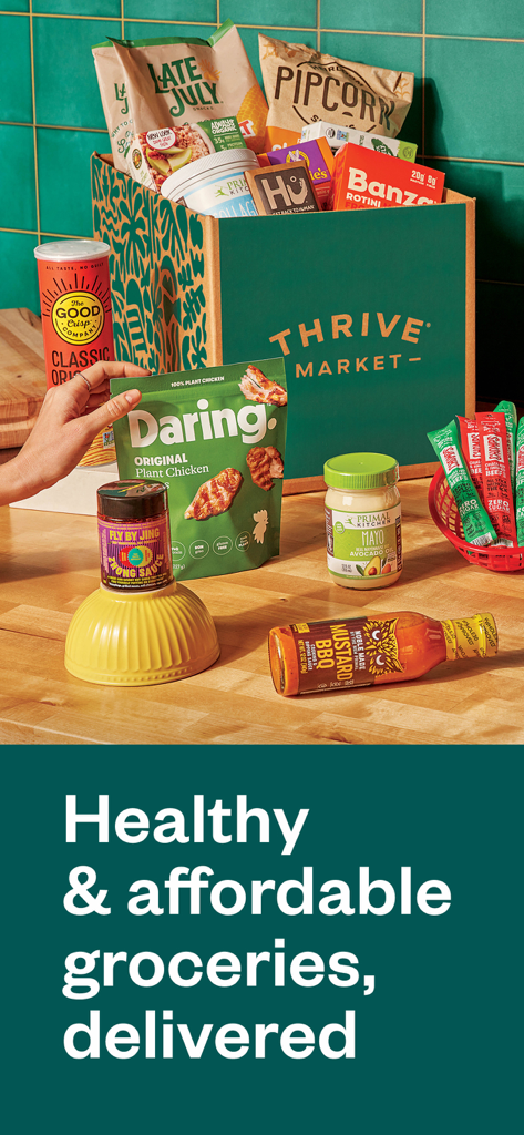 A Thrive Market box filled with various organic and healthy groceries on a kitchen counter.