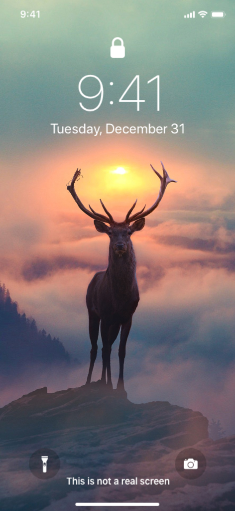 iPhone lock screen featuring a majestic deer standing on a rock with a sunset background