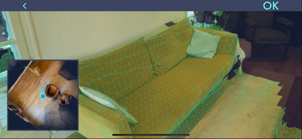 Smartphone interface showing a 3D scan of a room with a green mesh over a sofa