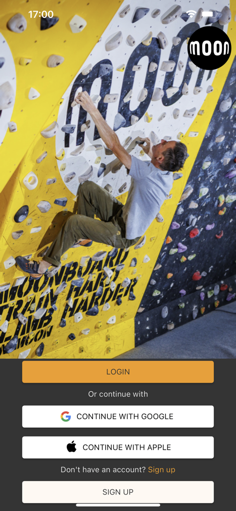 Moon Board - Login screen of the Moon Board app showing a climber on a training wall and sign in options