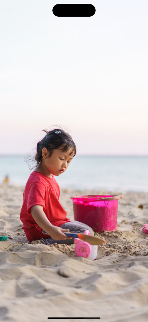 Sound Touch - Seasons (School) - A young girl in a red shirt playing with sand toys on a beach
