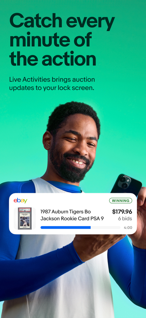 A man holding a smartphone displaying an eBay Live Activity notification for a winning bid on a collectible trading card.