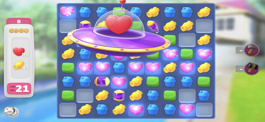 Home Decor - Interior Design - A match-3 puzzle gameplay screen with colorful icons and a UFO booster in the Home Decor Interior Design app