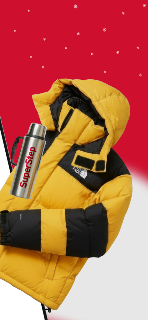 SuperStep - Una chaqueta acolchada North Face amarilla y negra junto a un termo plateado de la marca SuperStep sobre un fondo rojo de invierno.