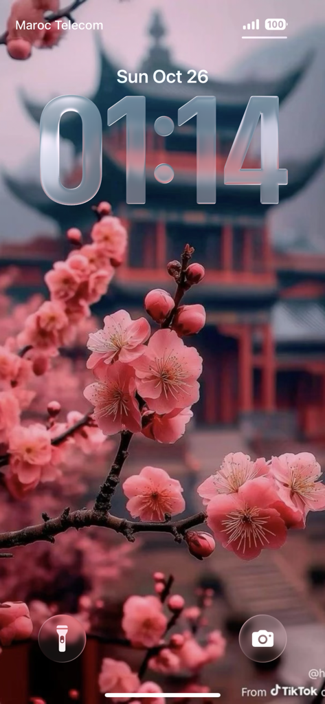 4K Wallpapers HD wallcraft - 深度効果とぼやけた五重塔の背景をフィーチャーした、美しいピンクの桜の壁紙のiPhoneロック画面。