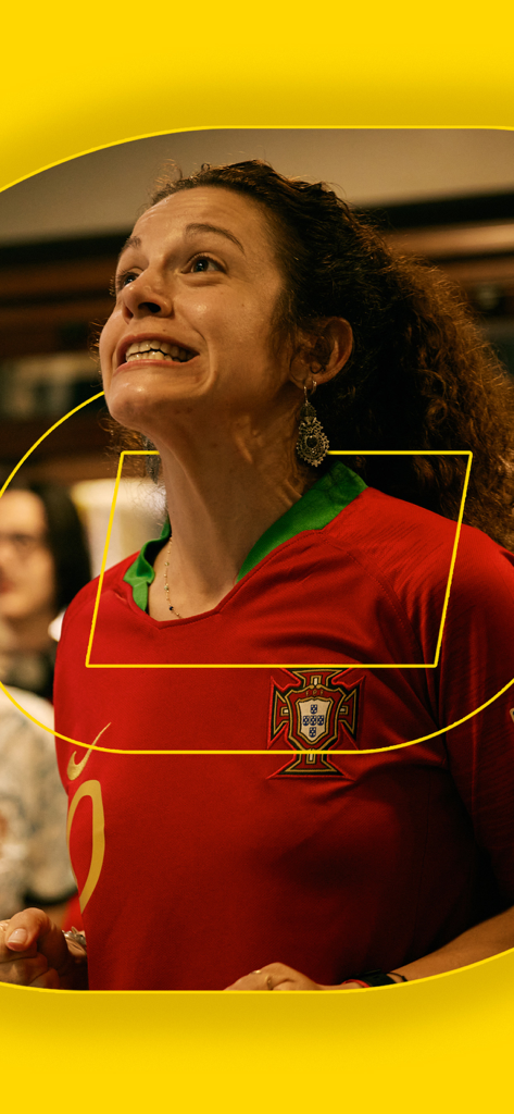 Fan femenina con camiseta de Portugal viendo un partido en un bar deportivo
