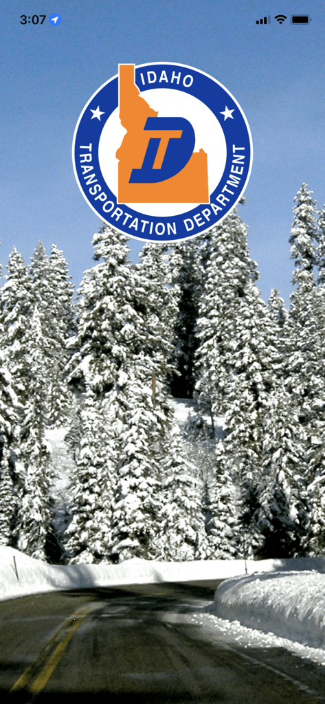 Idaho Transportation Department logo over a snowy mountain road and evergreen trees