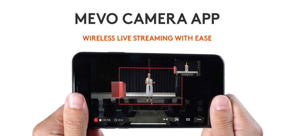 Logitech Mevo - Logitech Mevoアプリのインターフェースが表示されたスマートフォンを手に持ち、ワイヤレスライブストリーミングを行っている様子